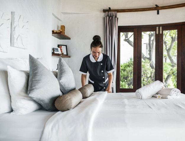 une femme de ménage nettoie une chambre d'hôtel photo premium